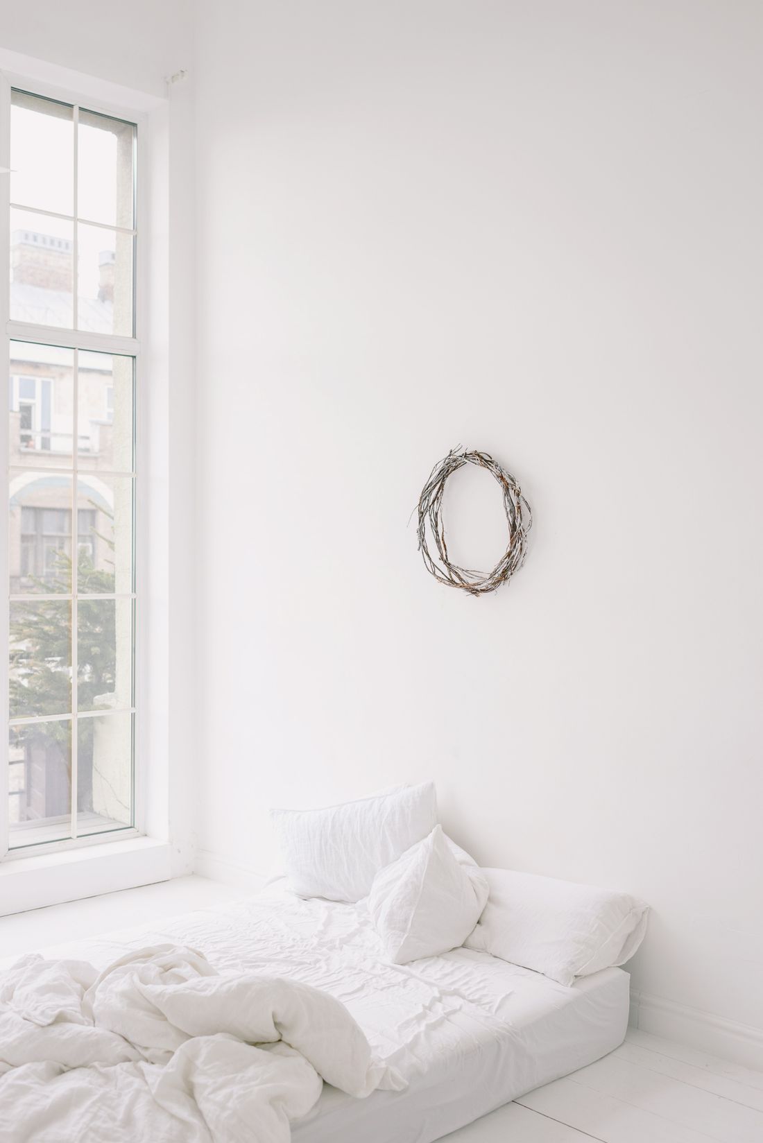 Sample bedroom with a white bed and a large window